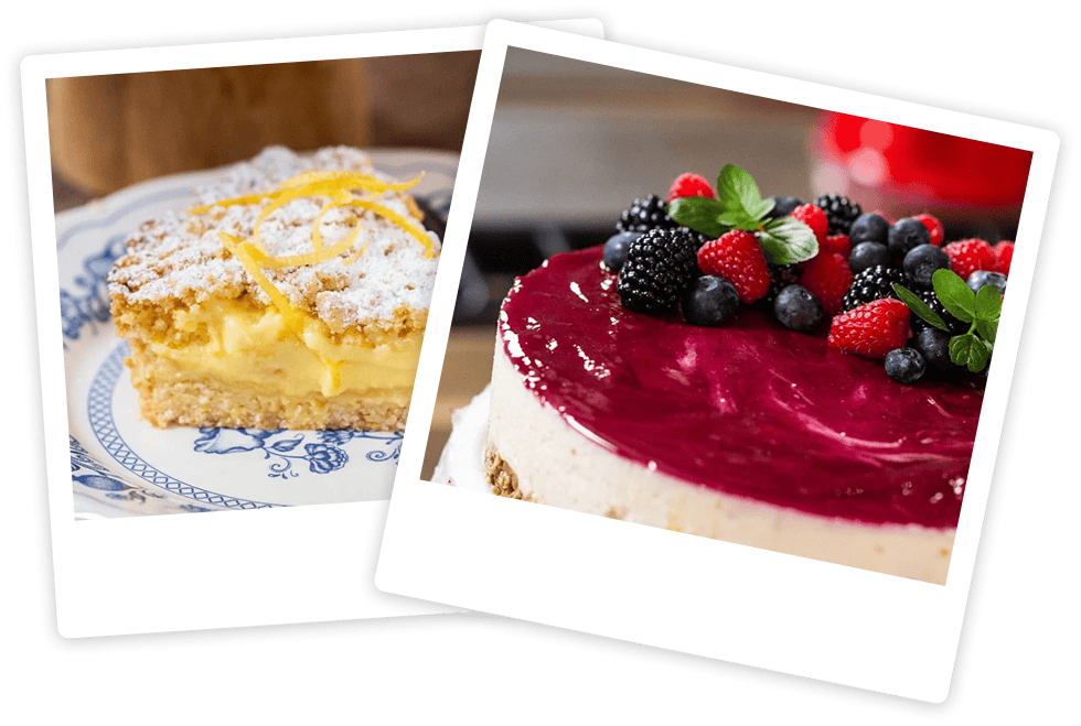 A slice of lemon cake dusted with powdered sugar beside a whole cheesecake topped with various fresh berries.